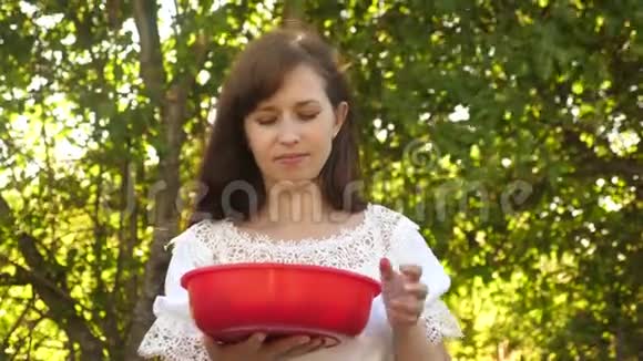 漂亮的女孩从杯子里吃红草莓微笑着妇女的维生素和浆果饮食快乐的女孩视频的预览图