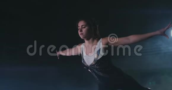 在烟雾中缓慢运动一个女运动员站着她的手臂举起后表演练习欢迎手势视频的预览图