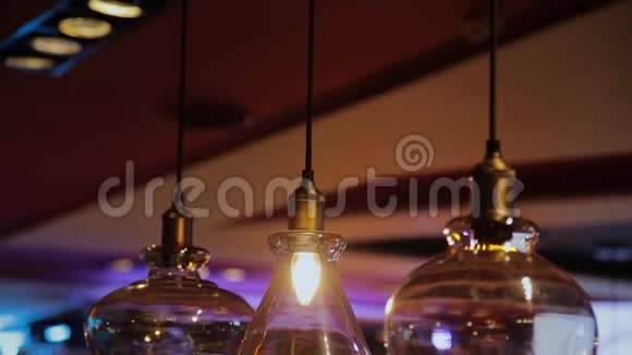 老式和复古黄色灯泡悬挂在黑暗背景在咖啡馆晚上许多豪华灯灯装饰视频的预览图