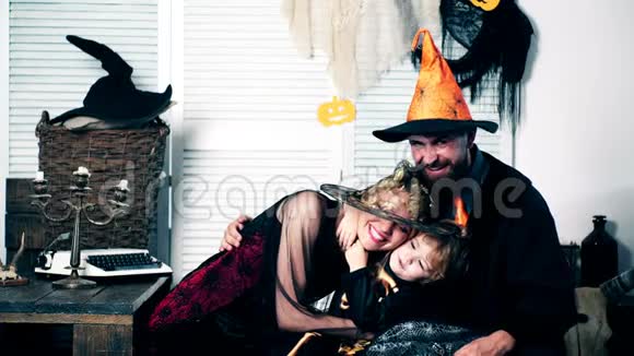 父亲母亲和他们的儿子穿着女巫女巫和骷髅的西装在万圣节假期拥抱万圣节视频的预览图