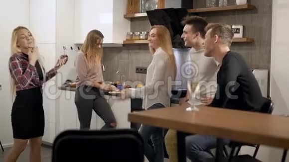 欢乐的男女学生在家庭聚会时在厨房里聊天笑着笑着视频的预览图