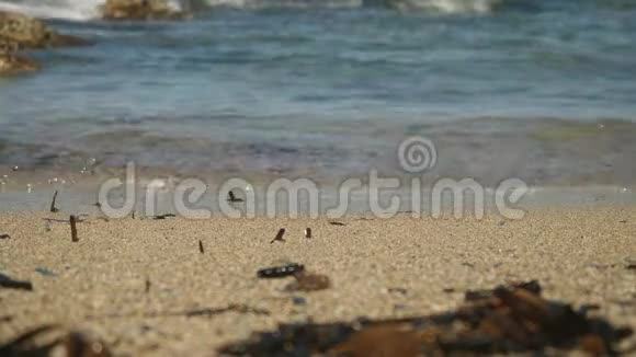 令人叹为观止的蓝色涟漪水溅在塞浦路斯沙滩上宏观视野模糊的岩石背景视频的预览图