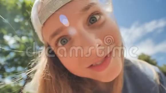 少女戴着一顶帽子在一个广角鱼眼镜头凸轮前摆出有趣的姿势面的特写视频的预览图