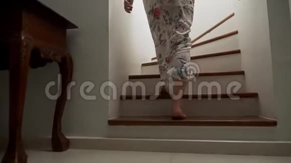 特写镜头女性赤脚走下木楼梯一个穿着漂亮长裙的女人走下楼梯视频的预览图