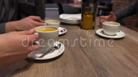 一群朋友在咖啡馆里叮当作响喝着茶双手特写视频的预览图