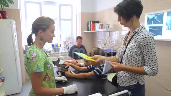 兽医诊所猫的一个年轻的女主人戴着白手套把文件递给护士48岁儿童视频的预览图