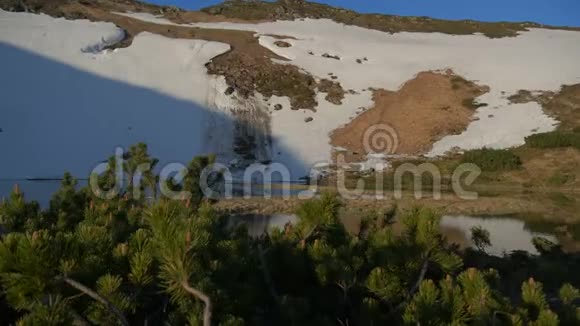 陡峭的斜坡雪和一个小湖在其脚下的喀尔巴阡山在斯洛文尼亚视频的预览图