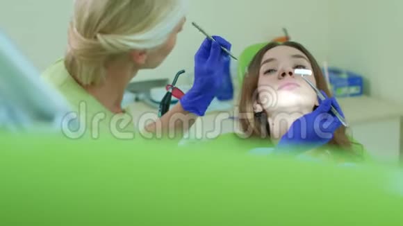 牙医把棉花卫生棉塞放进病人张开的嘴里牙科治疗工艺视频的预览图