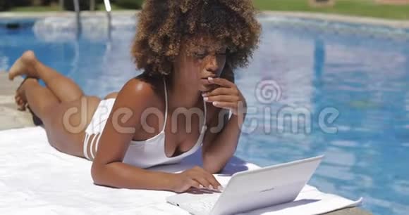 在游泳池里用笔记本电脑的迷人女孩视频的预览图