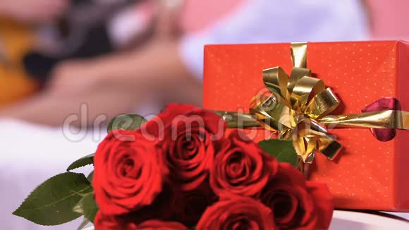 床上的礼物和玫瑰男人弹吉他为女人唱浪漫的情歌视频的预览图