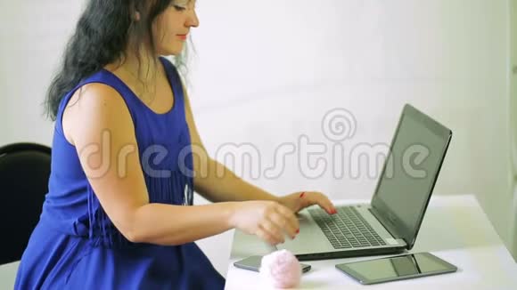 年轻女子在笔记本电脑上工作接电话摄像机从下往上移动视频的预览图