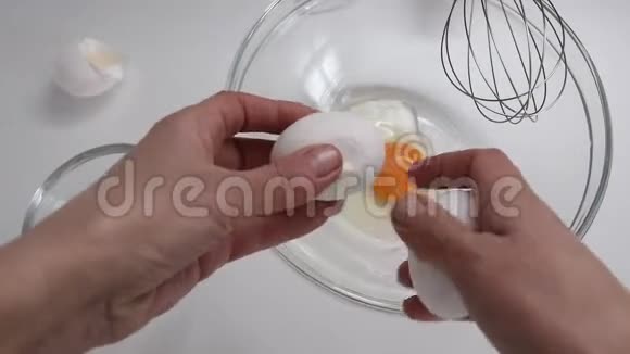 女人手破鸡蛋的俯视图生鸡蛋倒在碗里视频的预览图