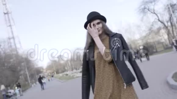 女孩走在街上肩上披着一件黑色的皮夹克一头长发飘扬视频的预览图