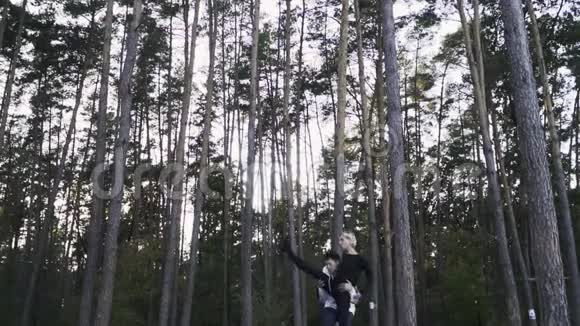 年轻夫妇在美丽的松树的背景下在森林里跳舞异族舞蹈情侣相爱他就是视频的预览图