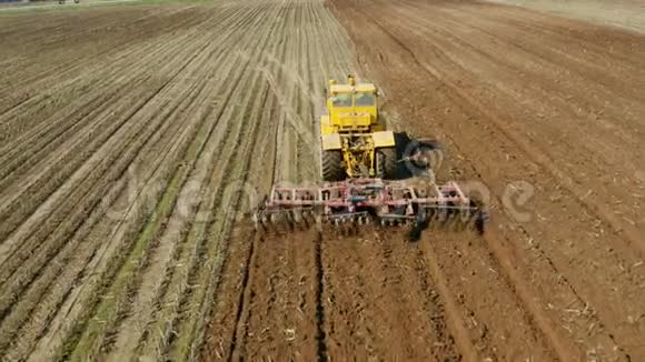 拖拉机与圆盘耙在农田顶部视图拖拉机在犁田里犁沟农业工作视频的预览图