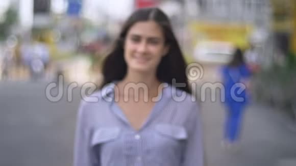 年轻迷人的女人走在城市的街道上美丽的黑发女人长发视频的预览图