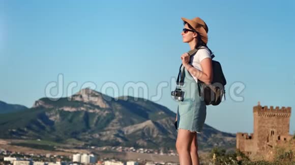 活动背包旅行的女人站在山顶欣赏令人惊叹的风景视频的预览图