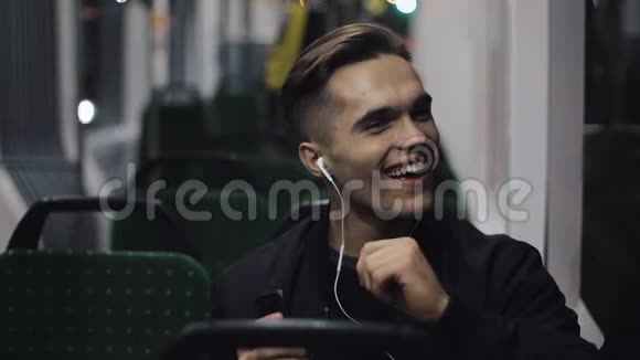戴着耳机听音乐的帅哥和坐在公共交通工具里的滑稽舞蹈他握着扶手视频的预览图