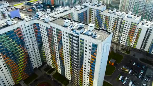 在一个夏天用鲜艳的彩色门面飞过住宅动作白色建筑的空中飞行视频的预览图