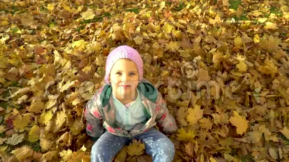 一个小女孩在秋天落叶中洗澡视频的预览图