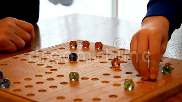 人们用橄榄石和骰子在自制的棋盘上玩家庭游戏视频的预览图