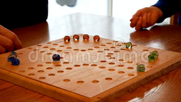 人们用橄榄石和骰子在自制的棋盘上玩家庭游戏视频的预览图