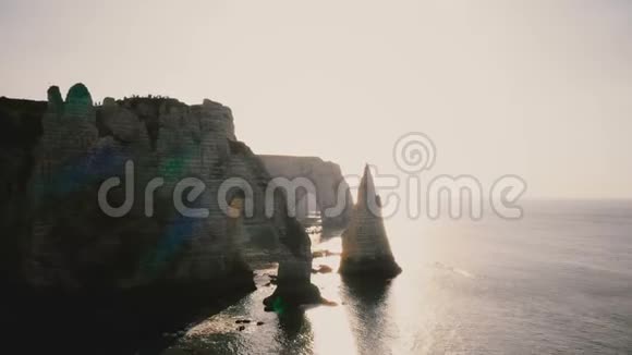 长长的空中天桥拍摄著名的白色悬崖在史诗般的日落诺曼底海岸与自然的岩石拱门和平静的波浪视频的预览图