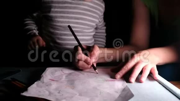 妈妈教孩子们如何用铅笔在一张纸上画一朵花特写视频的预览图