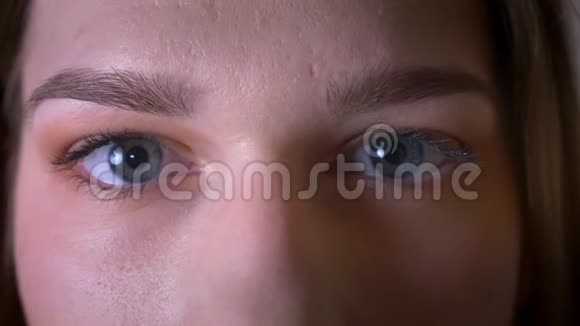 一张年轻的黑发女性脸的特写镜头眼睛看着镜头眨着眼睛视频的预览图