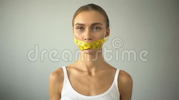 厌食症的女孩用胶带绑住嘴巴与吃汉堡的诱惑作斗争视频的预览图