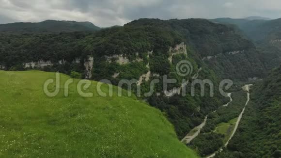 鸟瞰峡谷中的悬崖河流流过它山区的夏季景观视频的预览图
