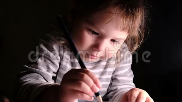 小女孩努力地在一张纸上画一支铅笔动作缓慢视频的预览图