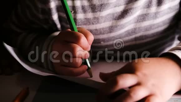小孩子把绿色铅笔画在一张纸上视频的预览图