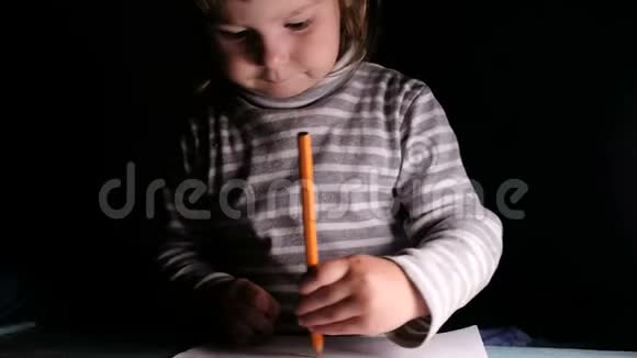 小女孩用橙色铅笔画画并表现出快乐的特写视频的预览图