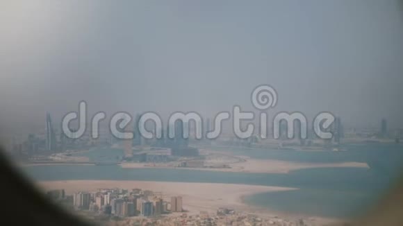 起飞后从飞机靠窗的座位上看到令人惊叹的背景景色雄伟的海洋和阳光明媚的沙漠城市视频的预览图
