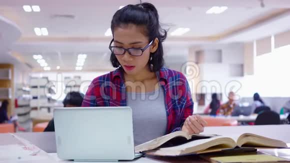 带笔记本电脑和书籍的图书馆学生学习视频的预览图