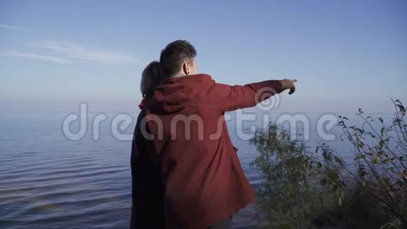 年轻夫妇站在水面的背景上一对情侣在户外约会年轻人的关系视频的预览图
