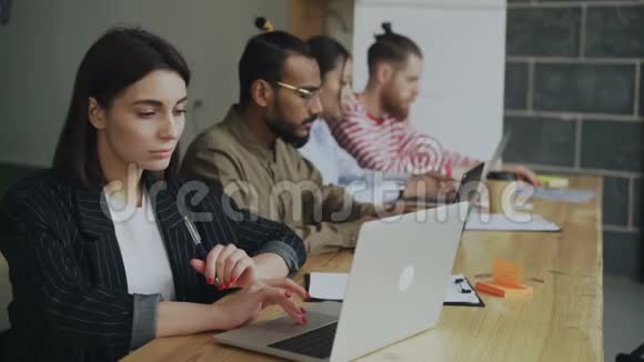 年轻的女企业家自由职业者在繁忙的同事办公室工作和使用笔记本电脑女商人和团队视频的预览图