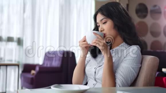 亚洲年轻女商人在舒适的室内坐在椅子上有空闲时间享受休息视频的预览图