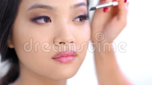 专业化妆师为美丽的亚洲模特特写打造时尚妆容视频的预览图