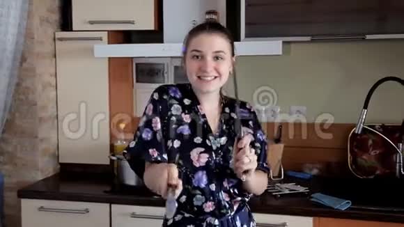一个年轻的女孩在厨房里打扫卫生开玩笑跳舞早上好心情视频的预览图