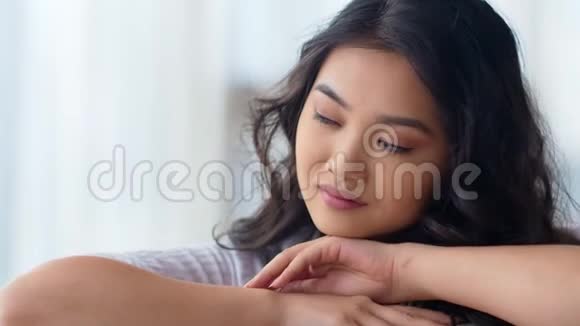 特写肖像谦虚的梦想微笑的亚洲女人头靠在手上视频的预览图