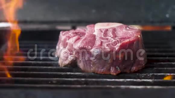 带骨头的新鲜生肉在火焰中烤慢动作特写视频的预览图