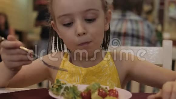 小女孩在餐馆里吃有食欲的绿色沙拉良好的健康观念视频的预览图