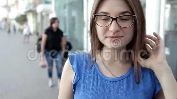一个女孩走过位于海滩上的城市微笑着为照相机摆姿势视频的预览图