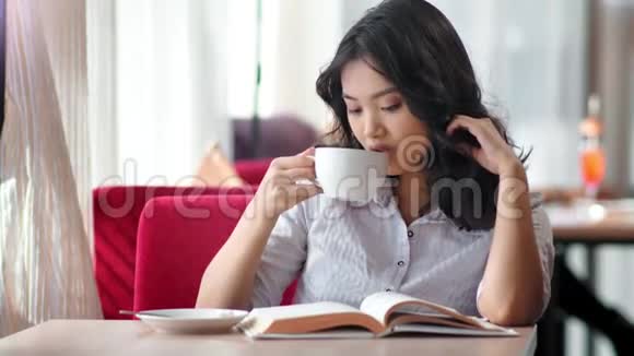 写真优雅年轻的女学生好好读书喝咖啡视频的预览图