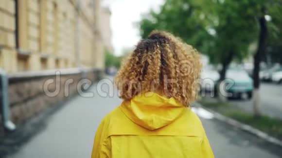 年轻漂亮的美国黑人女学生在街上行走转身看镜头的慢镜头画像视频的预览图