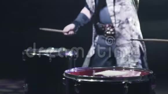 鼓手在鼓上敲打棍子行动鼓手在大鼓上敲击棍棒造成白色的飞溅视频的预览图