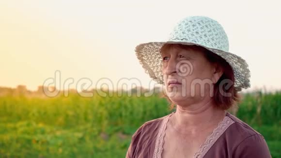 居住在农村的老年妇女的肖像一位成年妇女戴着一顶白帽子在欣赏风景视频的预览图