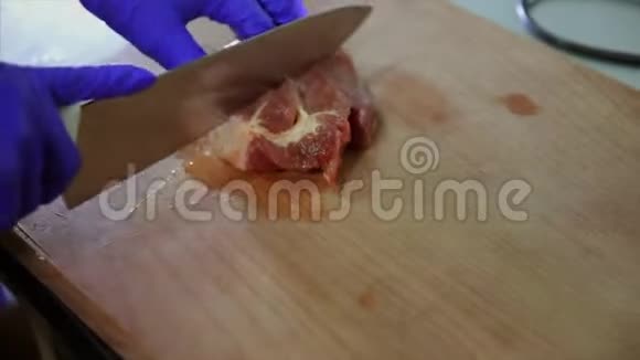 用刀子在木板上把生肉切成碎片的特写镜头视频的预览图